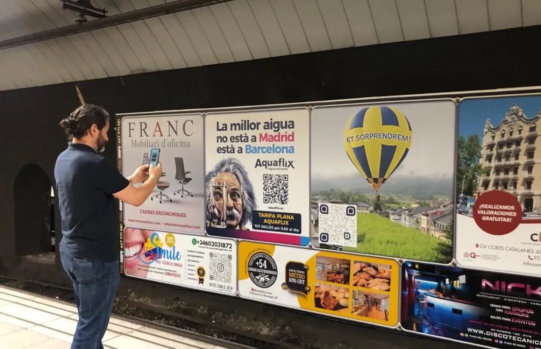 El regidor adjunt de Promoció Econòmica i Turisme de l’Ajuntament urgellenc, Jordi Mas, aquest matí a la parada de metro de Sants escanejant el QR de la  campanya publicitària de turisme de la Seu d'Urgell. 
