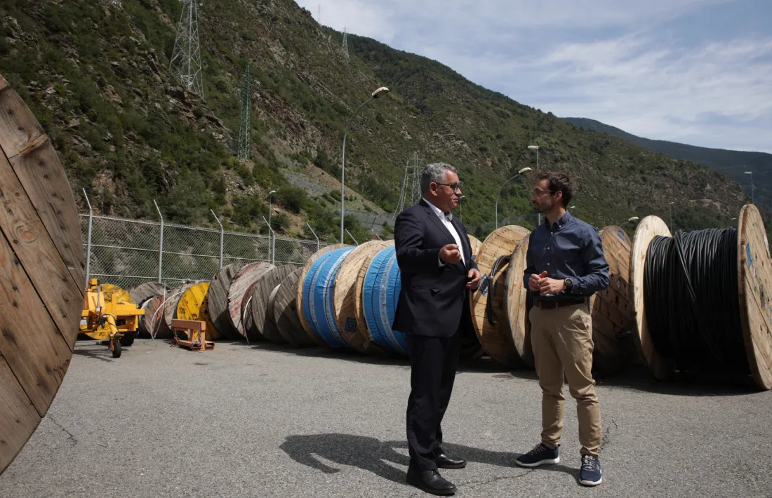 Albert Moles i Adrià Arasa conversant davant un dels trams de la nova línia d’alta tensió vist des del magatzem de FEDA.