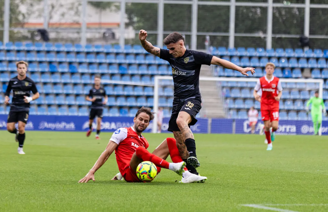 Mario Mourelo, l’extrem gallec de l’FC Santa Coloma, lluita per la pilota amb Hatzidiakos.