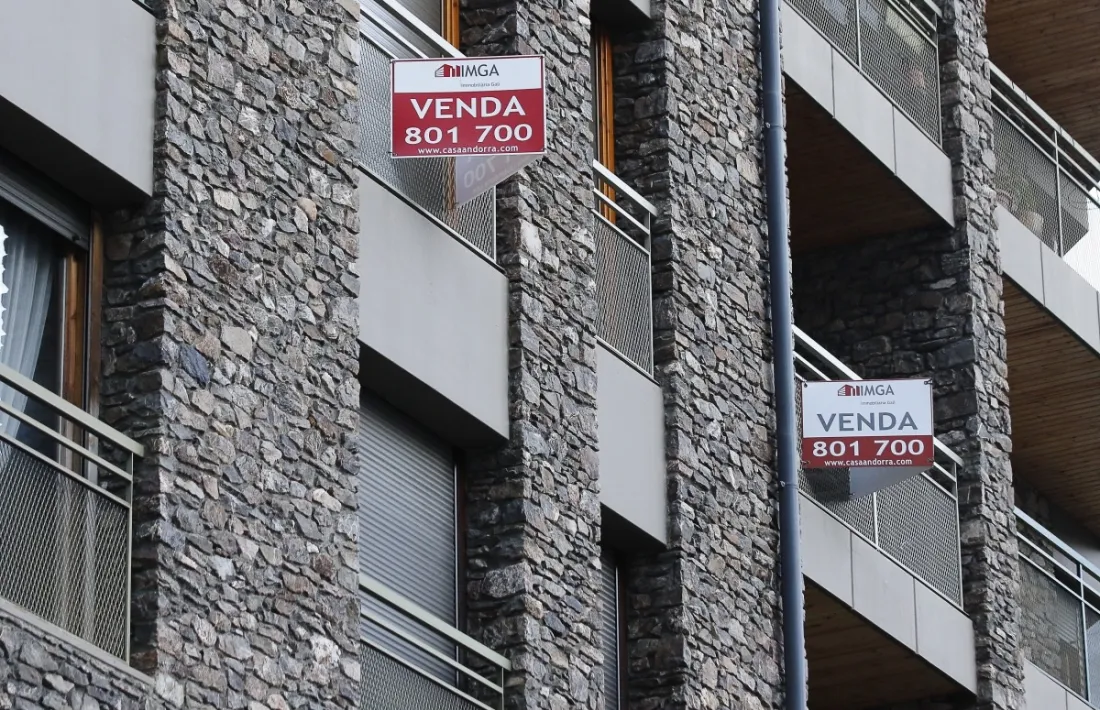 Un bloc de pisos amb cartells de venda.