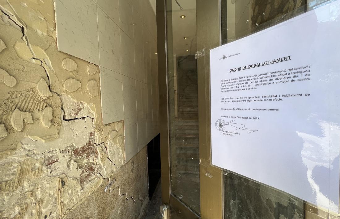 El cartell del desallotjament i les esquerdes en un dels edificis.