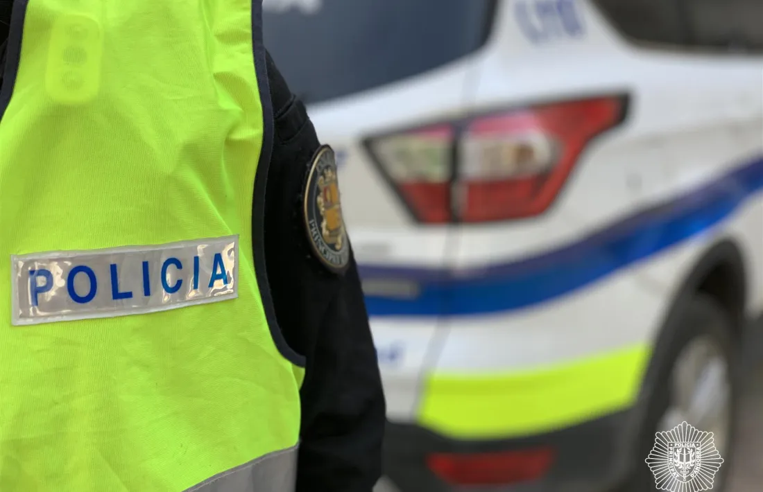 Un agent de policia al costat d'un vehicle del cos.