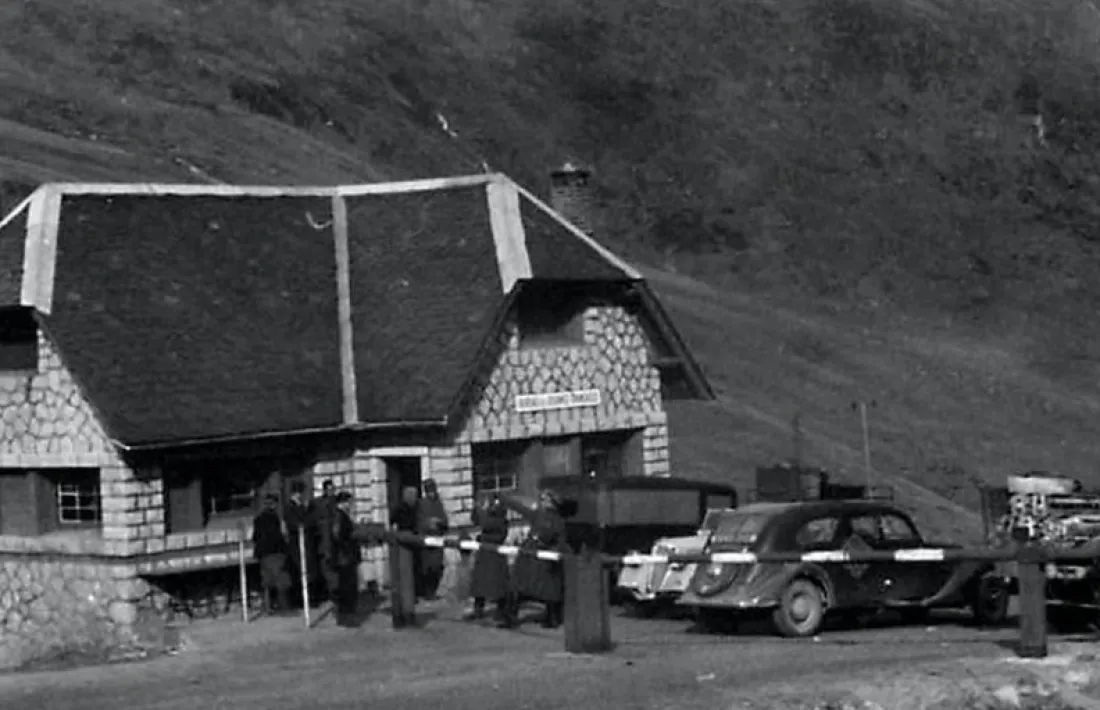 La duana francesa del Pas, amb un grup de civils del costat andorrà, i el que semblen dos oficials alemanys de l’altre. Un sembla saludar amb el braç enlaire, a la manera nazi. Ha d’estar feta entre el novembre del 1942 i l’agost del 1944, quan els alemanys van ocupar el que quedava de la França Lliure.