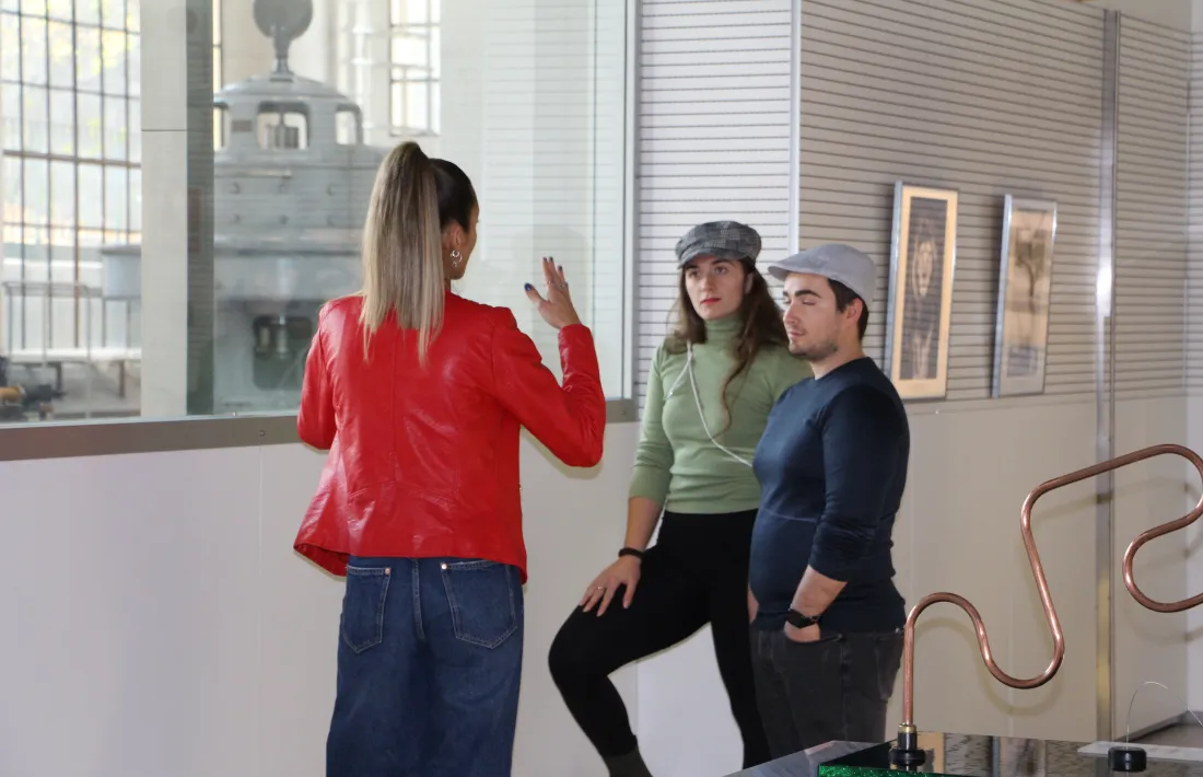 La guia del museu, Cristiana Cardoso, explicant l'exposició a dos visitants.