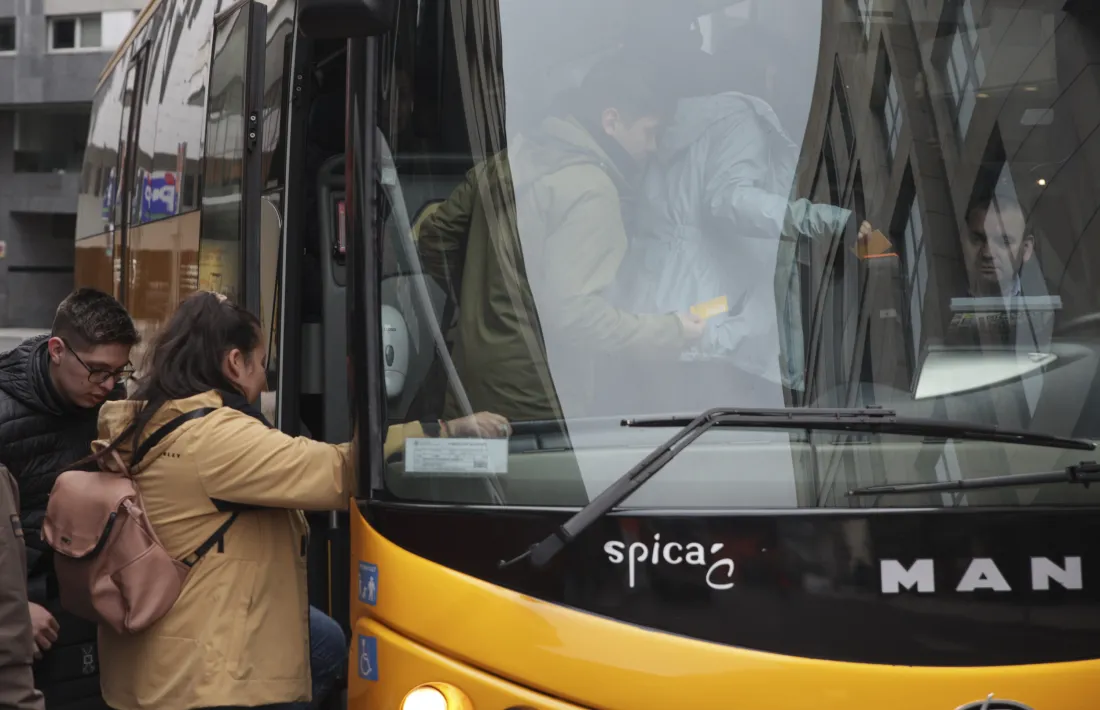 Uns usuaris fan cua per pujar a un dels autobusos interurbans, davant l’atenta mirada del xofer.