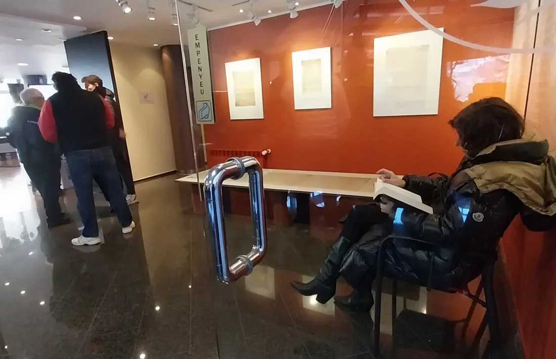 Qualsevol racó i moment és bo per a la lectura. Aquí, esperant la parella mentre vota. 