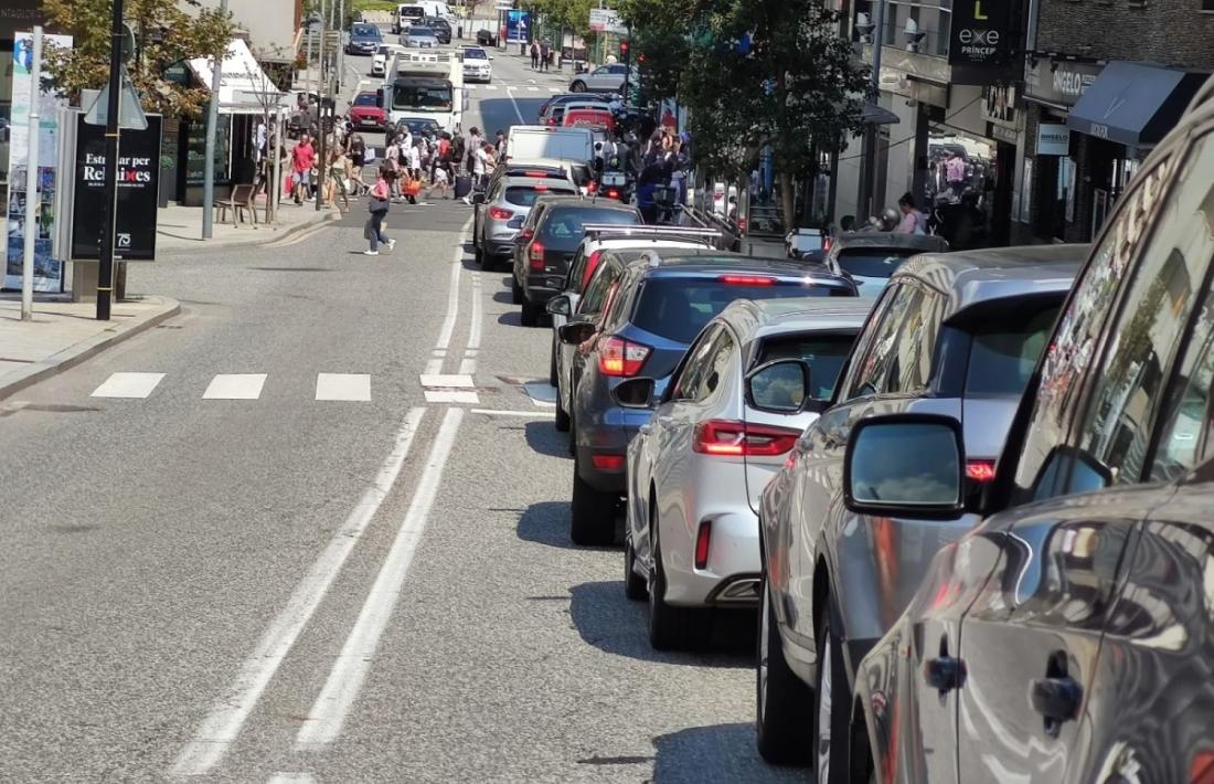 Una cua de vehicles i turistes al vial de la Unió.