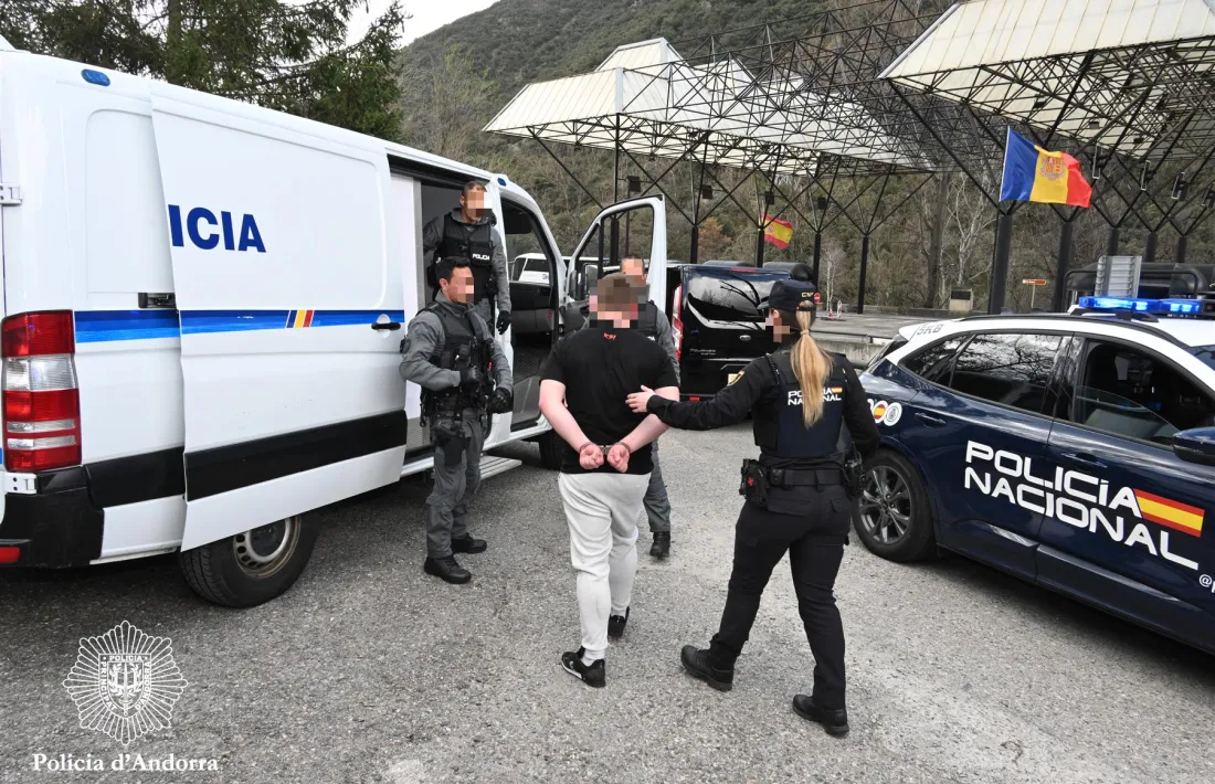 Una agent entrega un dels detinguts a la policia andorrana.