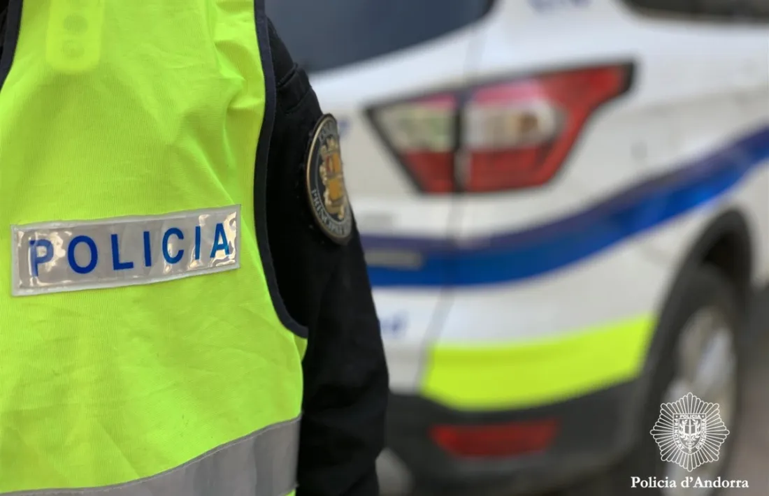 Un agent de policia davant un cotxe patrulla.