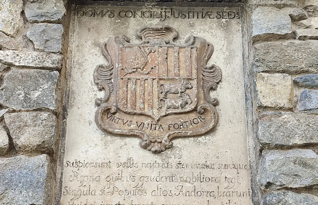 Escut d’Andorra a l’entrada de la Casa de la Vall, amb les dues vaques mirant cap a la dreta. 