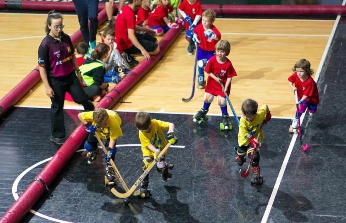 Infants jugant en un campus d'hoquei.