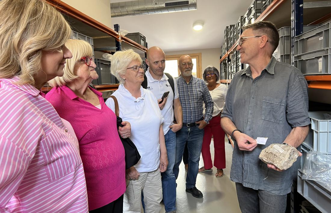 El director del museu d’Isona mostra alguns fòssils de la col·lecció als familiars del doctor Farré.