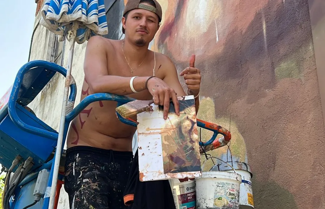 El muralista alturgellenc, enfilat a la grua per treballar a l’edifici escaldenc. 