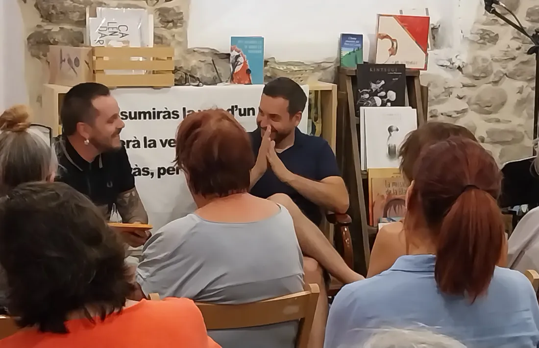 El cantautor Pau Alabajos, amb Miquel Albero, a la llibreria El Refugi. 