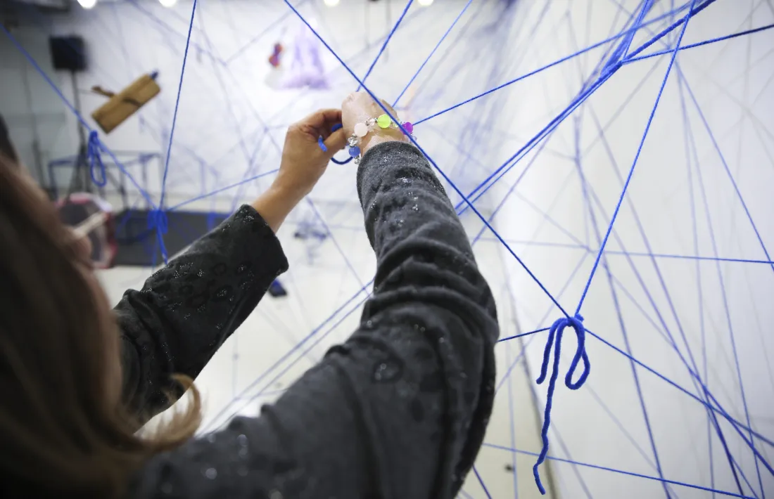 Diu Sergi González que recorda perfectament el seu primer dia a La Llacuna. Tenia 24 anys i començava el curs a l’Aula de Teatre, aleshores amb Pere Tomàs al capdavant. I que aquella primera impressió no l’ha oblidat mai. És una forma ben gràfica d’explicar la transcendència que aquest edifici ha tingut en la seva vida, com l’ha tingut en la de les més de 12.000 persones que durant els últims dos decennis han desfilat per l’Escola d’art, per l’Aula de Teatre i per l’Institut de Música, ara ja Conservatori. Recordem on érem, què fèiem i amb qui l’11-S, recordem el 17-A i alguns, com el cònsol de la capital, la primera vegada a La Llacuna. Parlem de fa dos decennis, els va fer exactament el 15 de setembre, i quan comences a recordar coses de vint anys enrere fa una mica de vertigen, que volen que els digui. Però ahir no era dia de vertigen, sinó d’aniversari i de celebració, perquè el que no és llicència poètica, sinó estricta realitat, és que La Llacuna és –ho deia de nou González– un dels cors de la parròquia, un d’aquests edificis singulars que generen vida en una ciutat, que bateguen. Perquè La Llacuna batega. Ho demostren les pures xifres –aquests més de 12.000 alumnes, els 2.500 esdeveniments que s’han programat a la sala d’actes i els 110.000 espectadors que hi han desfilat, els tres centenars d’exposicions, els 150 professors que hi han impartit classe i el centenar d’associacions que han tingut i tenen la seu a l’Espai d’entitats ciutadanes que es va estrenar el 2013. La Llacuna és tot això, sí, però és molt més que tot això. I ho va sintetitzar perfectament la cònsol menor, Olalla Losada: “Més enllà de l’art i de la cultura, imprescindibles per generar una societat sana, crítica i cohesionada, La Llacuna ha generat comunitat”.  I és precisament aquesta comunitat la que simbolitza la instal·lació/performance creada pels alumnes de les tres escoles de la Llacuna amb què ahir al vespre va arrencar el modest cartell per celebrar l’aniversari: es titula Lligams, i consisteix en essència en una xarxa de cordó blau, que ho és de La Llacuna, que vincula simbòlicament les disciplines que s’hi imparteixen i que representa també les relacions humanes que s’hi han anat teixint al llarg els anys. Una estupenda simbiosi de dansa, música i arts plàstiques que es pot contemplar al vestíbul de l’edifici i que va acabar amb l’acròbata, Júlia Guàrdia, repartint trossets de cordill entre els assistents. Es tractava que en acabar l’acte els lliguéssim a la xarxa mare i cal dir que, lamentablement, només s’hi van animar quatre gats.  Losada va tenir un record per a Conxita Mora, la cònsol que va tenir la idea visionària de comprar l’antiga seu del Centre Moral i Recreatiu i concentrar-hi les escoles de música, art i teatre fins aleshores disperses per la parròquia. Ella el va concebre i l’honor d’inagurar La Llacuna va ser per al seu successor, Xavier Mora. Va ser, com ja s’ha dit, el 15 de setembre del 2004. El d’ahir era el primer acte del cartell d’aniversari. Seguirà una taula rodona sobre cultura popular (2 d’octubre) i l’espectacle de carrer Flotados, el 16 d’octubre a la  plaça Guillemó.