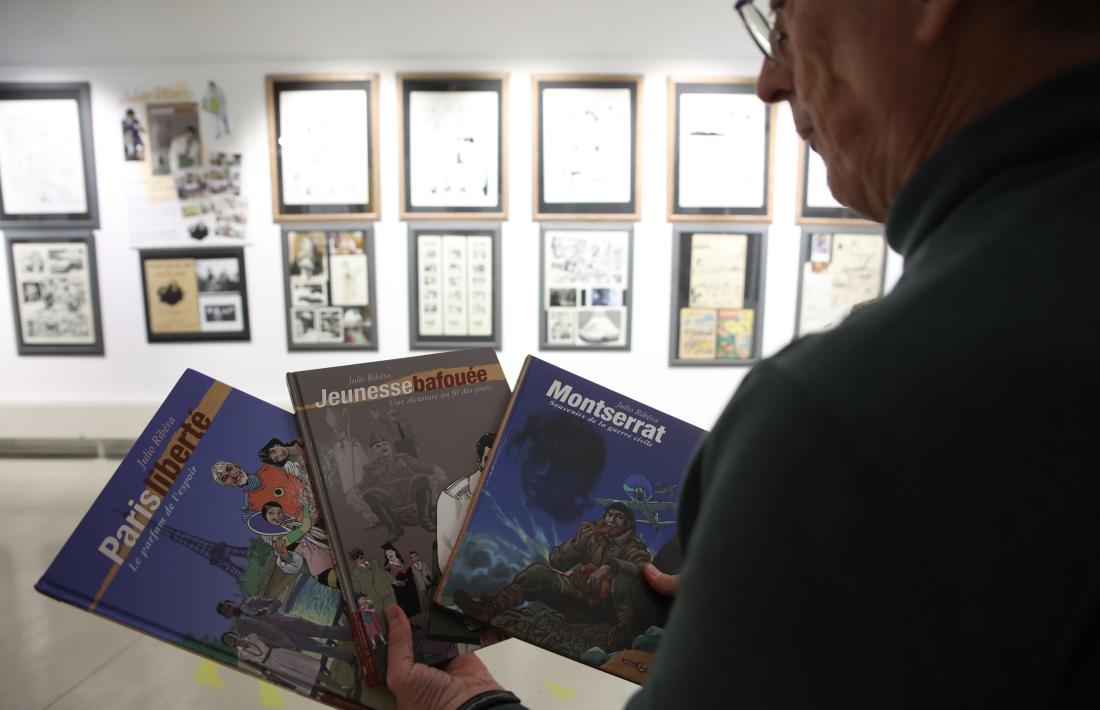 Joan Pieras observa els tres exemplars de les memòries, coeditades per Amaníaco i pel Museu del Còmic.