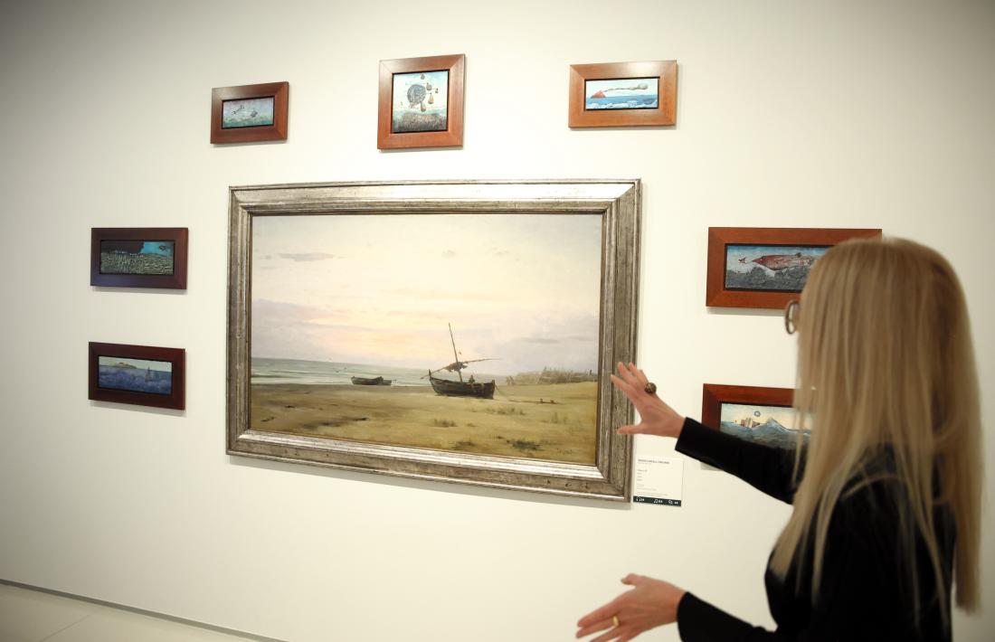 La comissària, Pilar Giró, davant de la marina de Modest Urgell, envoltada de set minúsculs paisatges de Cuixart.