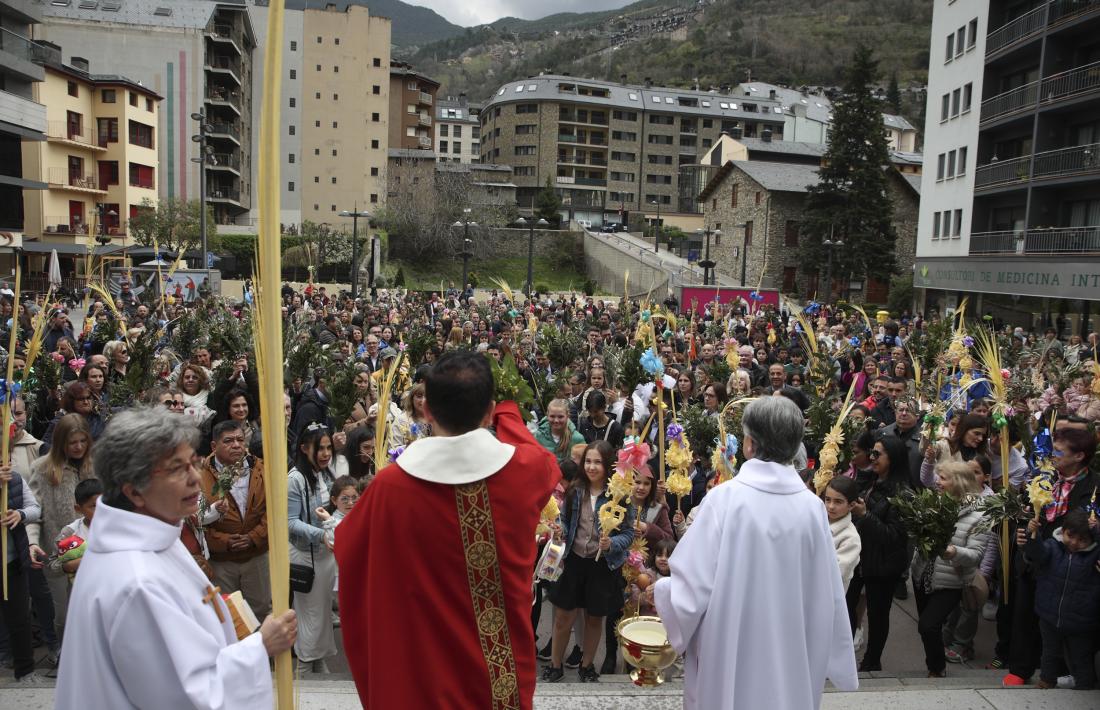 Mossèn Pepe, a punt de beneir palmes i palmons en una plaça plena a vessar.