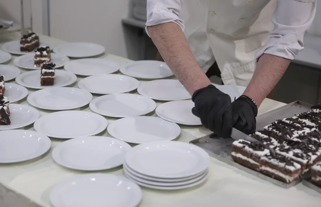 Un treballador de la restauració emplatant unes postres.