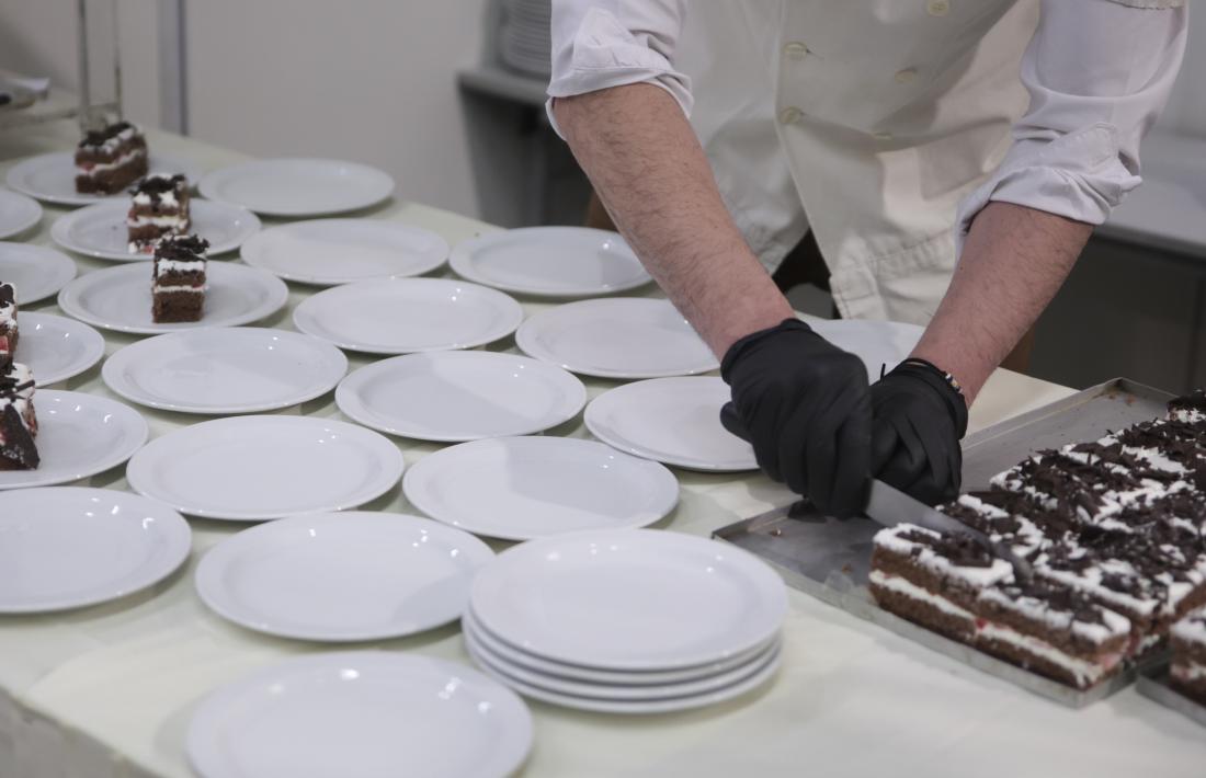 Un treballador de la restauració emplatant unes postres.
