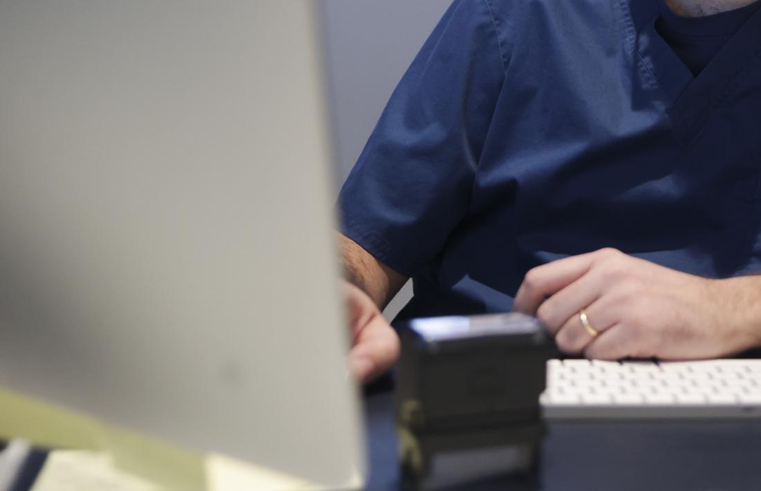 Un metge treballant davant d'un ordinador.