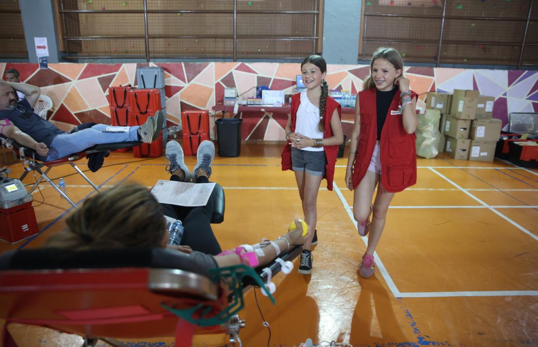 L’Emma i la Clara en acció, atenent un dels donants de sang, aquest migdia al col·legi Sant Eremengol.