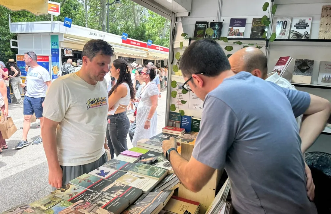 Oliver Vergés atén un client a la parada dels editors al Retiro.