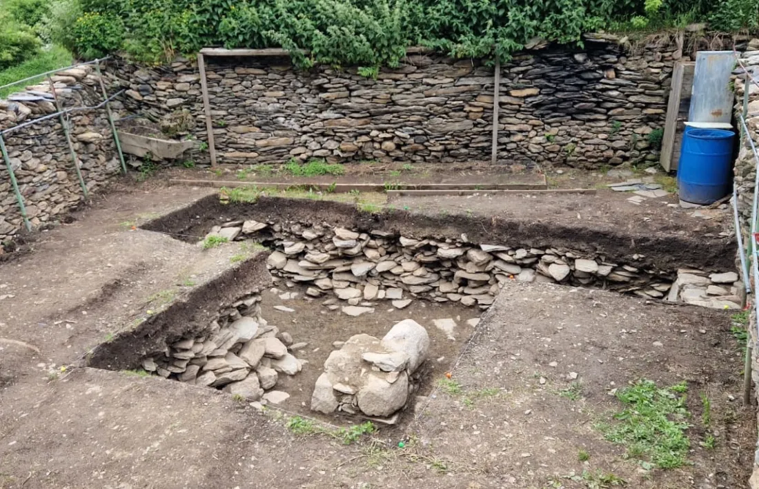 En primer pla, l’estructura de pedra que els arqueòlegs interpreten com la base de columna d’una borda o era (però no d’una església).