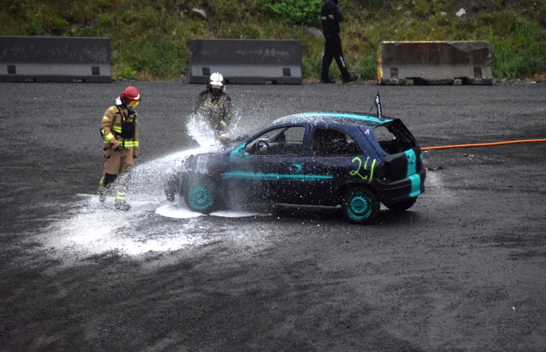 Els bombers ruixant el motor d’un dels cotxes participants.