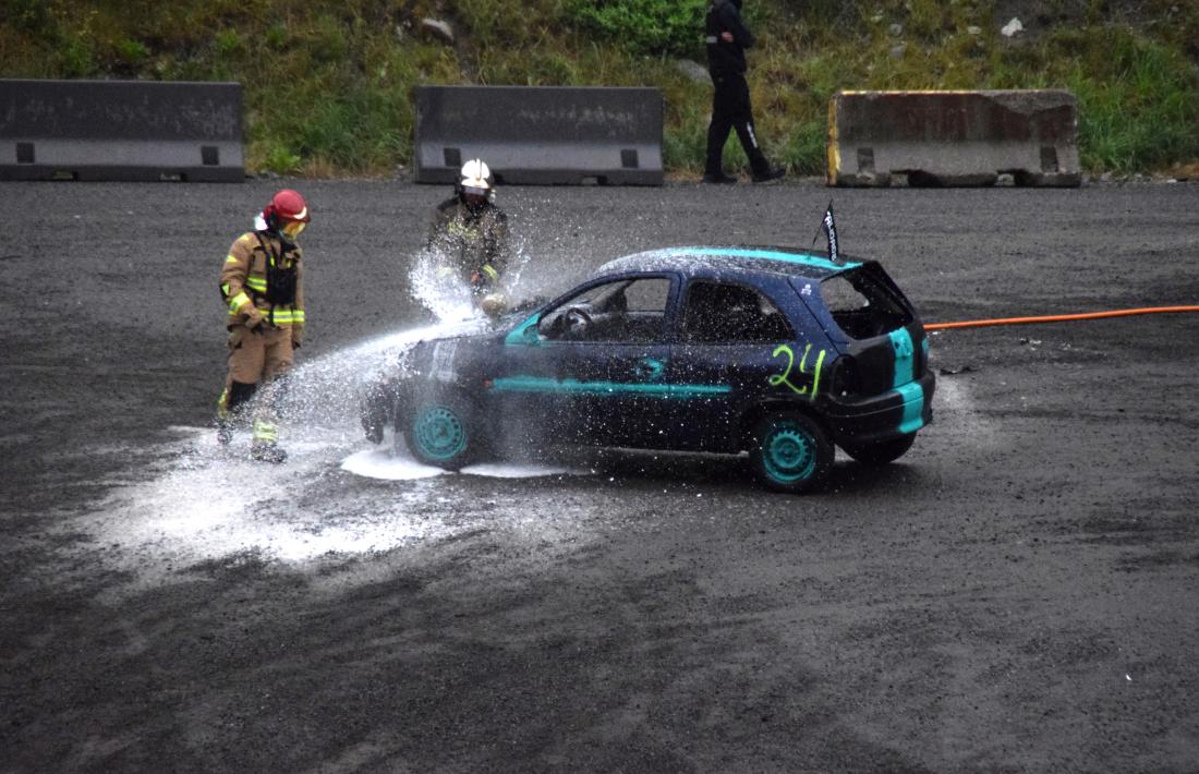 Els bombers ruixant el motor d’un dels cotxes participants.