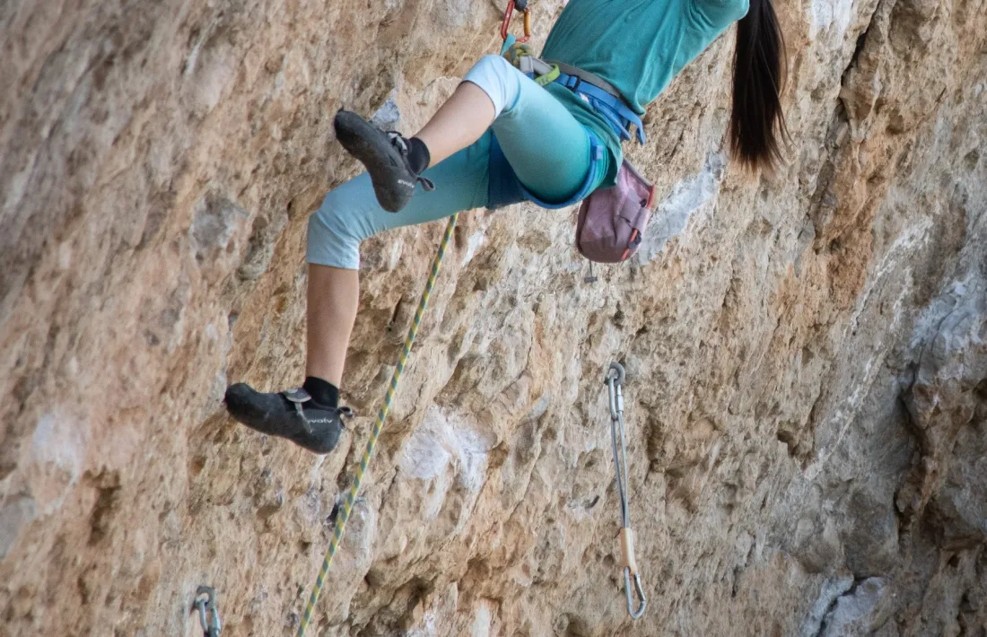 La jove escaladora, enfrontant-se a la immensa paret de 50 metres d'alçada.