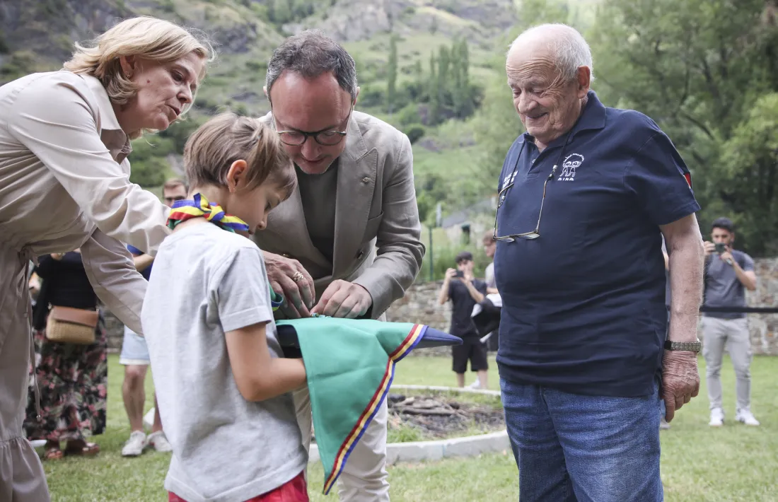 Una nena porta la medalla perquè Espot li posi a mossèn Ramon.