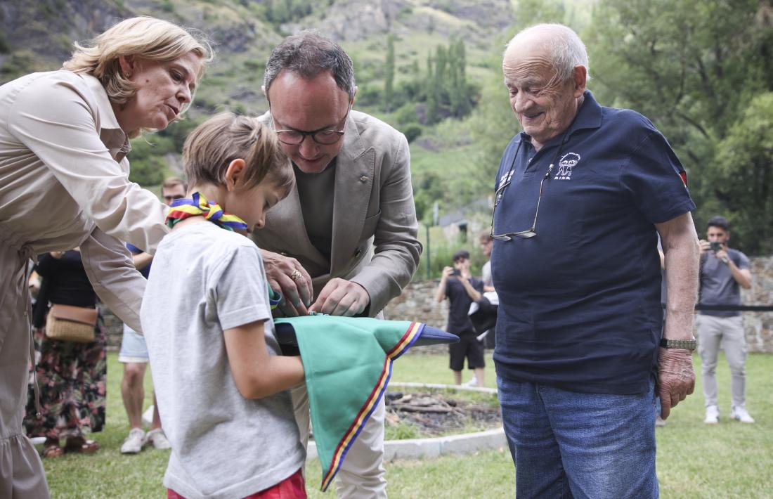 Una nena porta la medalla perquè Espot li posi a mossèn Ramon.