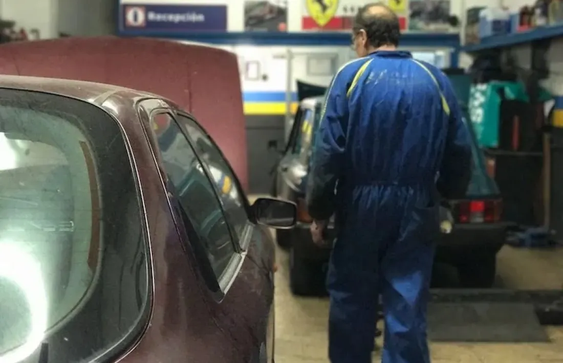 Un mecànic inspecciona un turisme en un taller.