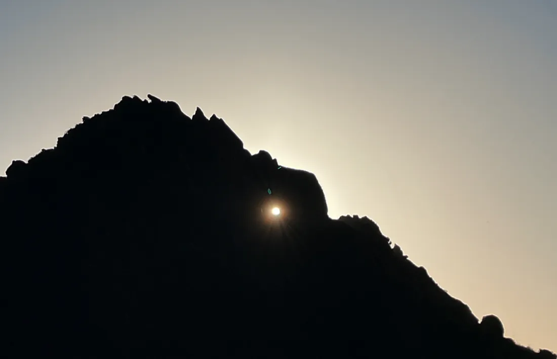 Els raigs del sol travessen un forat natural al cim d'Arcalís.