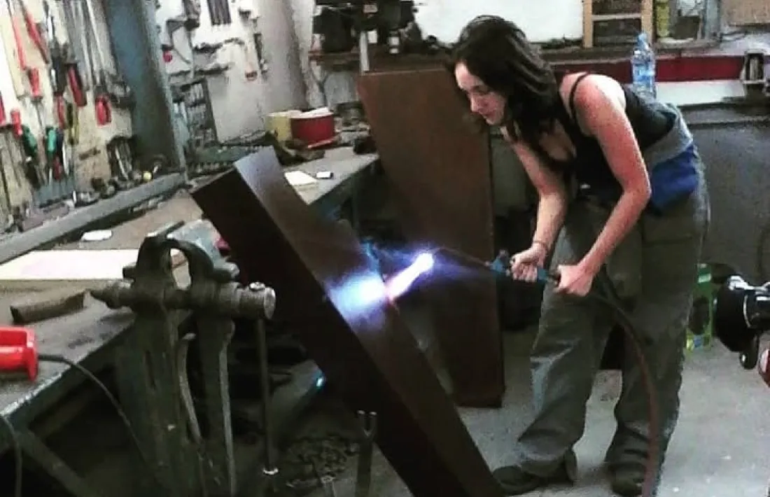 Regada, al taller, treballant en una peça similar. 