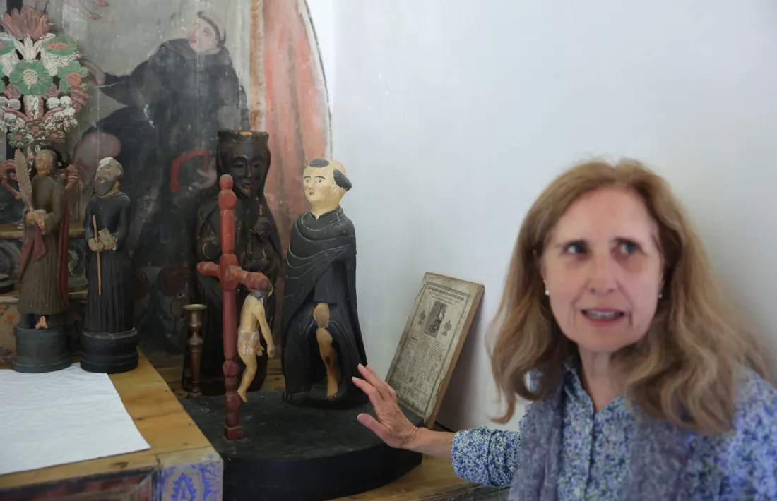 Gina Lezau amb la talla del patró, i al davant, Crist baixant de la Creu.