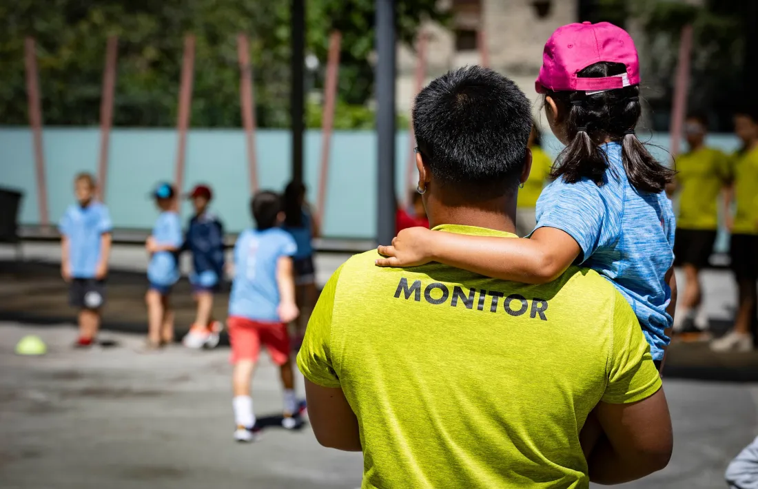 Un monitor i un grup de nens i nenes fent una activitat de lleure.
