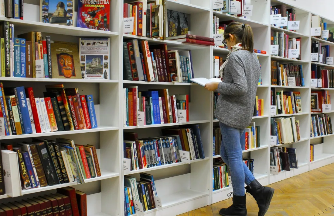 Una estudiant en una biblioteca fent recerca.