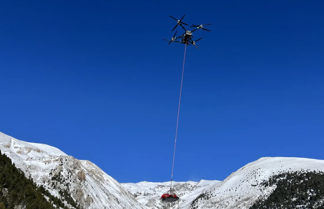 El dron, en plena actuació i amb la camilla en l'aire.