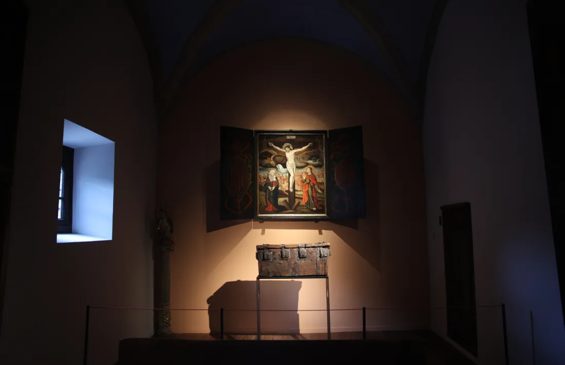 El retaule de la Crucifixió amb l'urna de les Sis Claus als peus, a l'antiga capella.