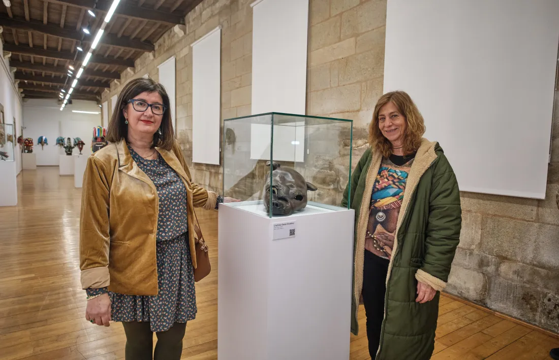 La directora de la Cátedra de Estudios de la Tradición de l'UVa, Pilar Panero, i la conservadora de la col·lecció Alas y Viento, Conxita Pérez, posant amb la màscara de l'ossa d'Ordino.