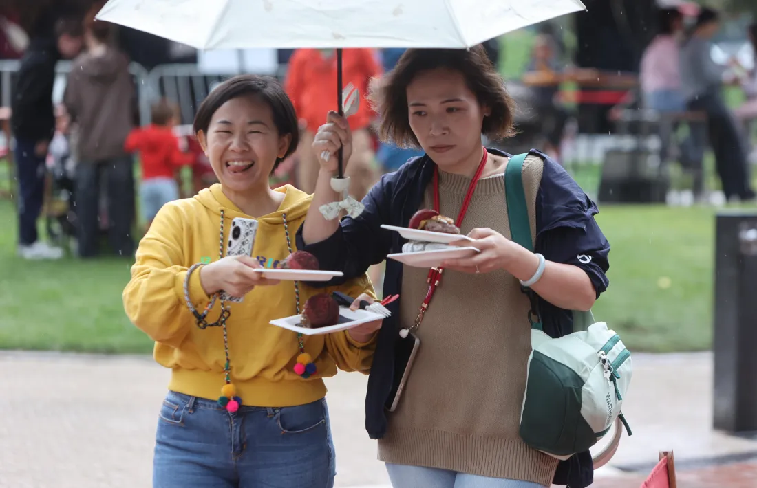 Dues turistes gaudint de l’Andorra Taste 2025 tot i la pluja, un dels esdeveniments que atrau visitants.