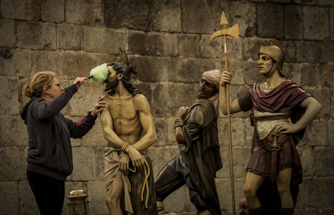 Treure la pols a les escultures que portaran en processó, un dels passos previs del Divendres Sant. 