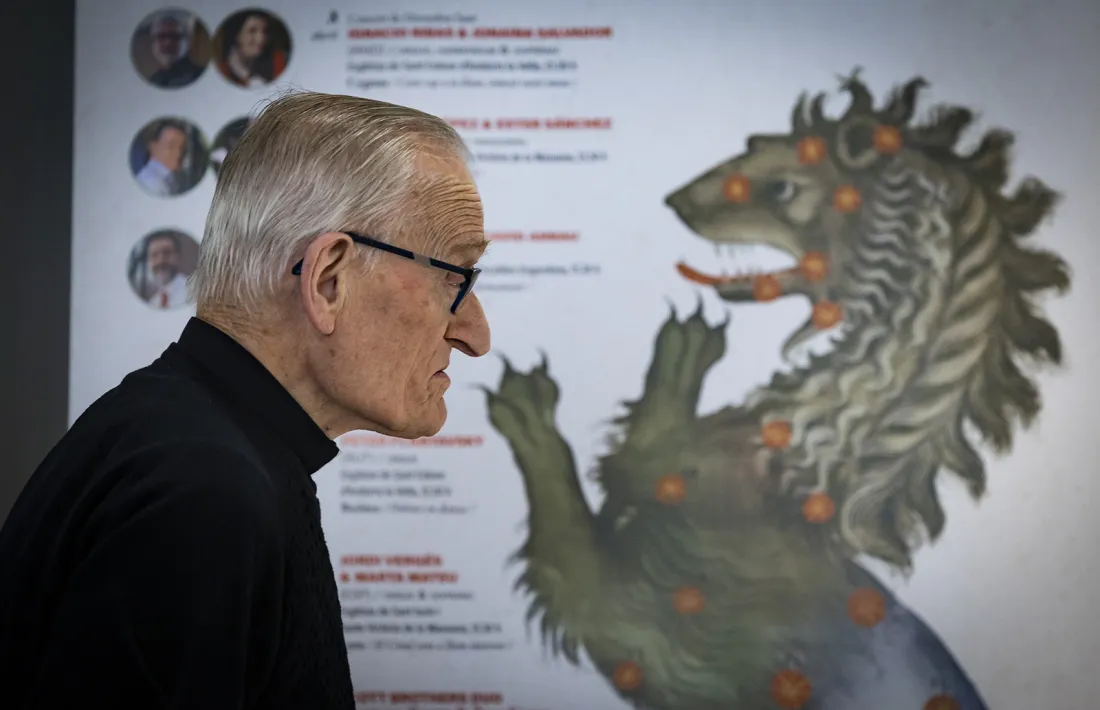 Mossèn Ramon Sàrries observa el cartell del festival: cada concert sota l'advocació d'una constel·lació.