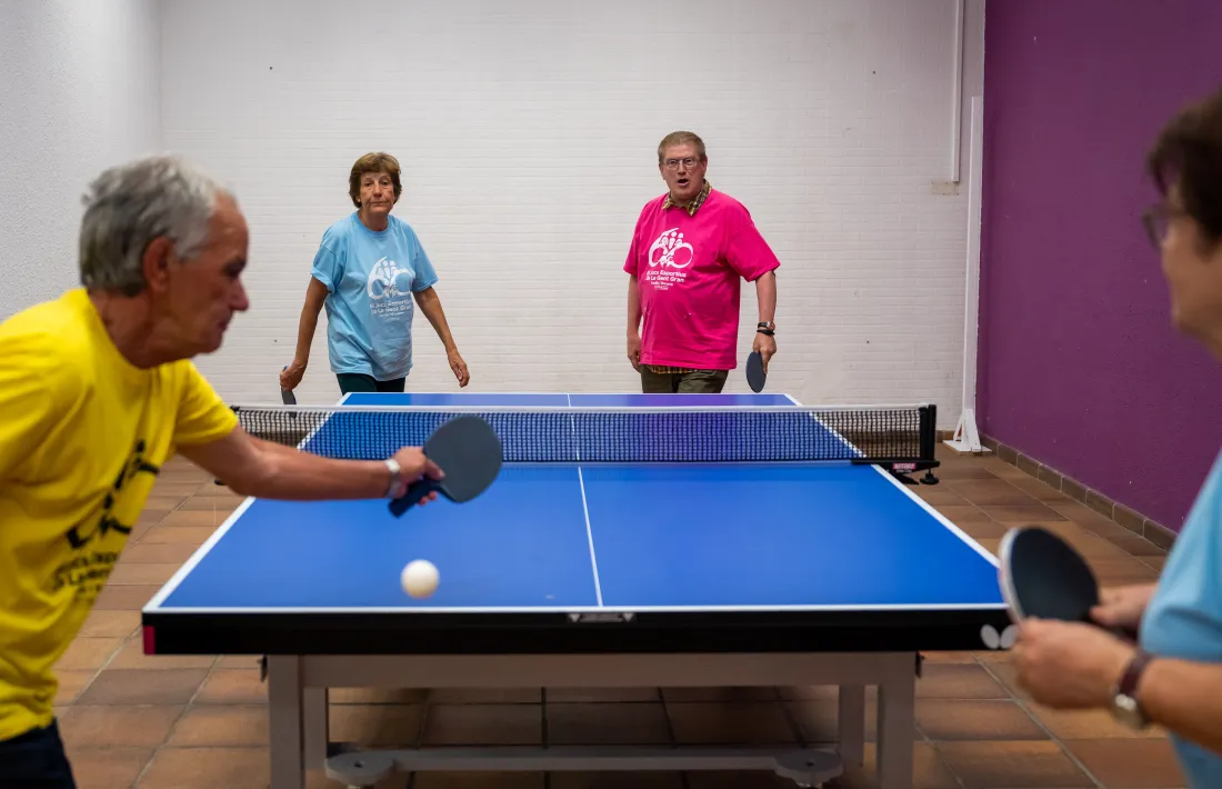 Uns padrins jugant a tennis taula.