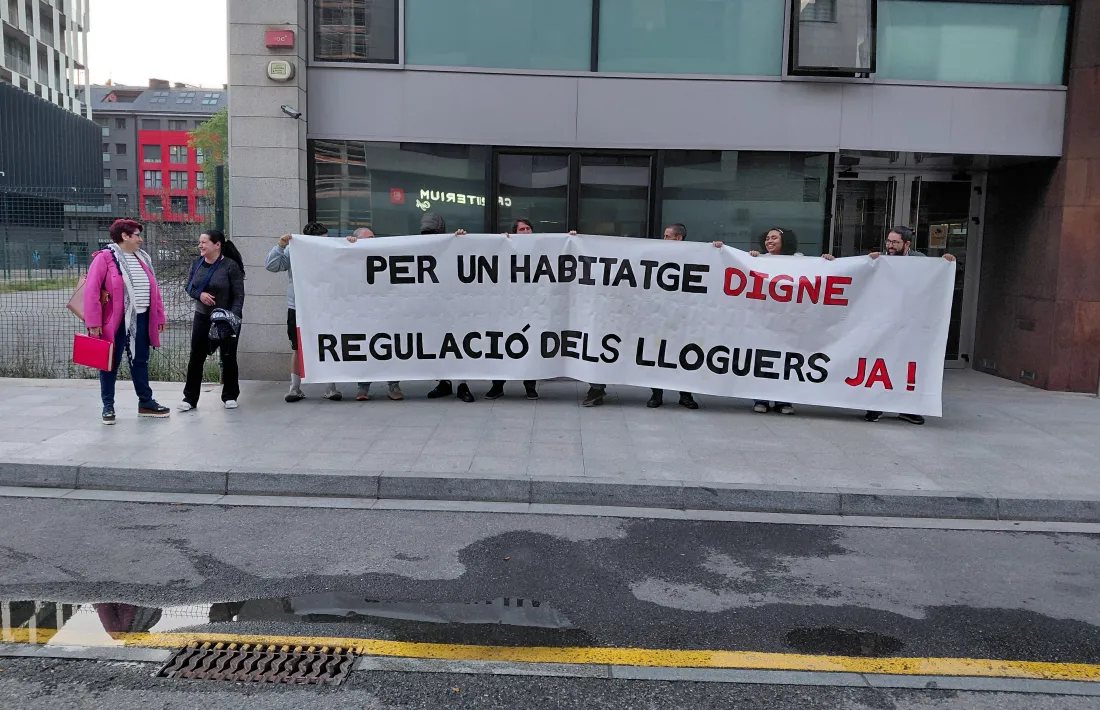 Integrants del Sindicat d'Habitatge d'Andorra amb una pancarta a l'entrada de l'edifici del Prat del Rull.