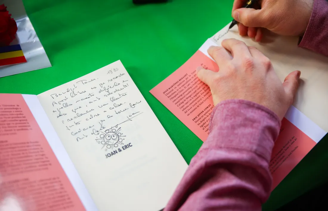 Joan Martínez Benazet i Eric Jover estampen els exemplars de 'Divendres 13', amb una caricatura del virus del SARS-CoV-2 obra de Jordi Planelles.